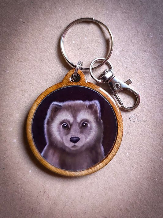 Close-up of a wolf-themed wooden keychain with a detailed illustration, eco-friendly and handmade, perfect for animal lovers