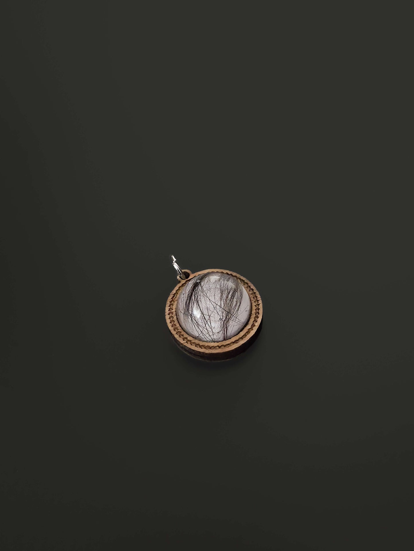Close-up of wooden and resin memorial pendants on black background