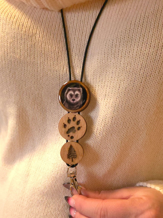 Ahma-avainnauha keychain with dog face, paw print, and tree designs