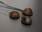 Close-up of wooden memorial pendants with hair inside